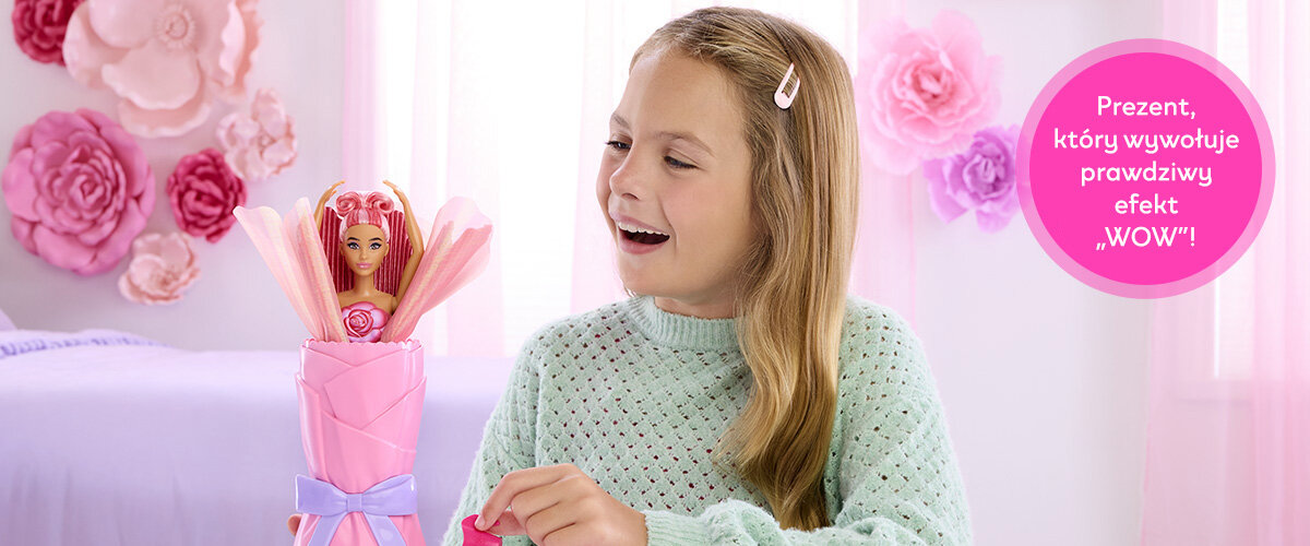 Dziewczynka bawiąca się lalką Barbie w pokoju, obok widnieje napis 'Prezent, który wywołuje prawdziwy efekt WOW!'.