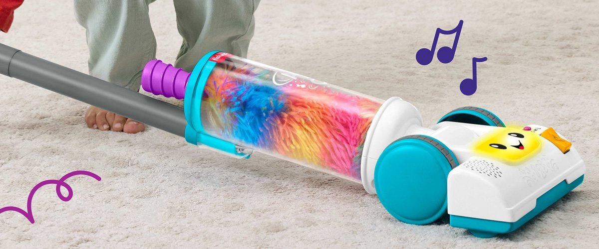 Dziecko bawiące się zabawkowym odkurzaczem Fisher Price.