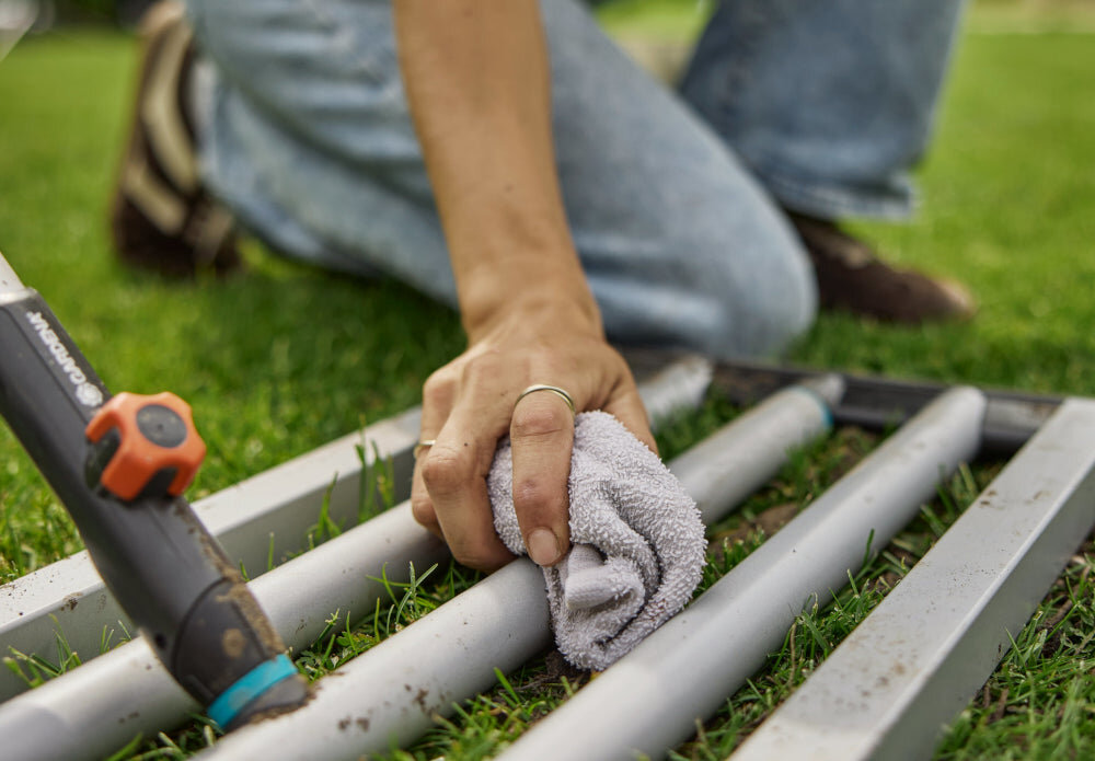 Niwelator terenu GARDENA Combisystem 03569-20 ogród trawnik osoba czyści niwelator za pomocą szmatki montaż narzędzia jest prosty i zajmuje tylko chwilę zamknięte panele ograniczają gromadzenie się zabrudzeń ułatwia czyszczenie