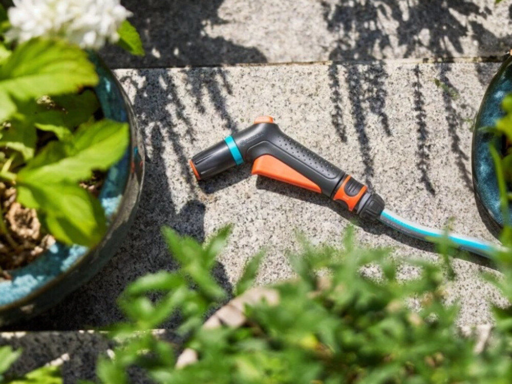 Pistolet zraszający GARDENA Classic 18360-20, temperatura, głowica, zestawy, spłukiwanie, pistolet leży na kamiennej podłodze wśród roślin doniczkowych