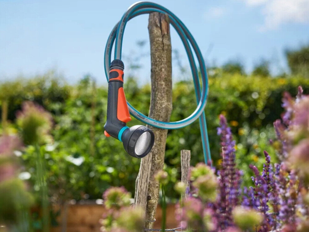 Pistolet zraszający GARDENA Classic 18365-20, UV, przymrozki, solidny, wielosezonowy, pistolet wraz z wężem otulone wokół patyka w ogrodzie