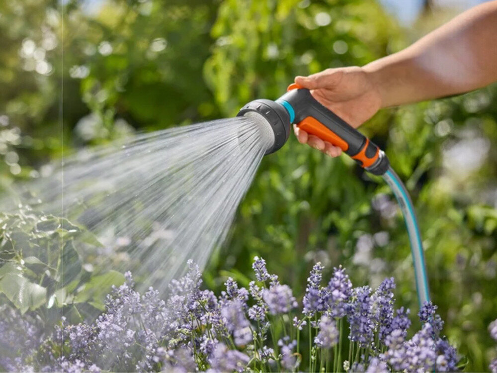 Pistolet zraszający GARDENA Classic 18367-20, kciuk, 20%, 100%, doniczka, dłoń trzyma pistolet podpięty do węża z wodą i podlewa krzaczki