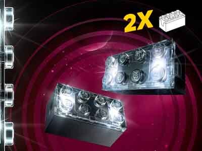 Obraz przedstawia dwa przezroczyste klocki LEGO z podświetleniem na tle fioletowych okręgów. W prawym górnym rogu widnieje napis \'2X\' oraz symbol klocka LEGO.