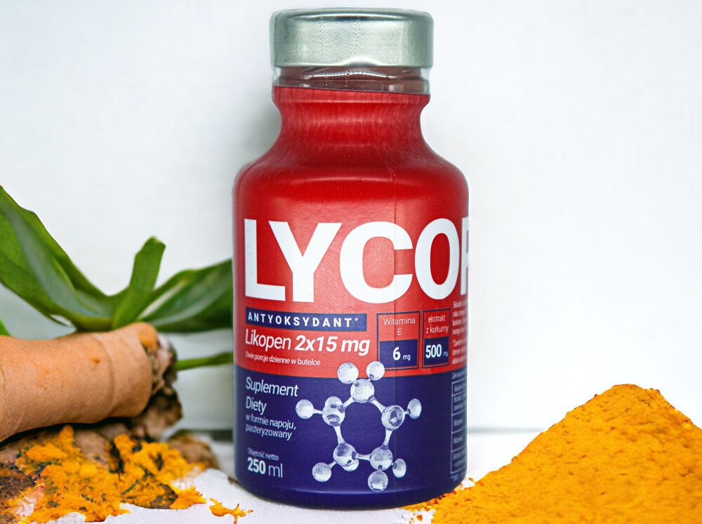Napój LYCOPEN Antyoxidant Drink Witamina E + Kurkuma 15 x 250 ml butelka na blacie z wysypaną kurkumą połączenie likopenu witaminy C kurkuminy i witaminy E działa synergistycznie właściwości przeciwutleniające wspiera organizm w walce z przewlekłymi chorobami długoterminowe zdrowie