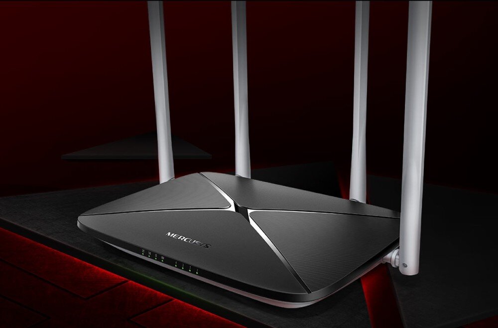 Router MERCUSYS AC12 Router widoczny pod kątem od przodu. Urządzenie ma czarną, matową obudowę ze srebrnymi, dekoracyjnymi liniami. Widoczne są cztery pionowe anteny skierowane ku górze, opis