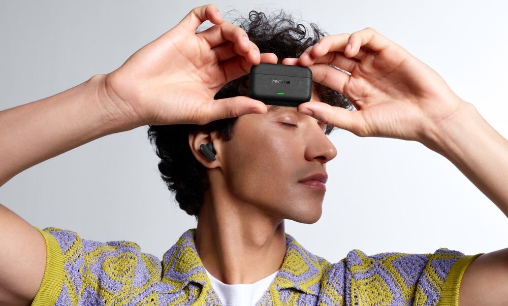 Słuchawki dokanałowe REALME Buds T500 Pro ANC Hi-Res Audio LHDC 5.0 przetwornik 12,4 mm dźwięk przestrzenny 360 detale audio, osoba z założonymi słuchawkami dokanałowymi trzymająca w ręku etui