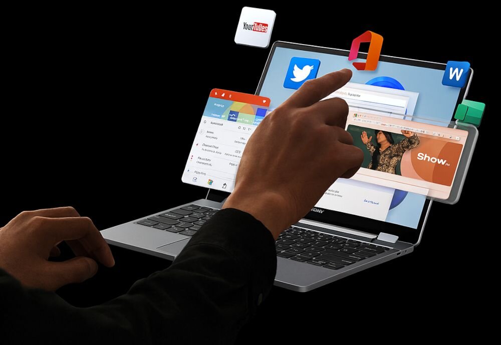 Osoba obsługuje laptopa z ekranem dotykowym, na którym widoczne są ikony aplikacji takich jak YouTube, Twitter i pakiet biurowy. Na ekranie otwarte są różne okna, w tym przeglądarka internetowa z napisem \'Show.\'.