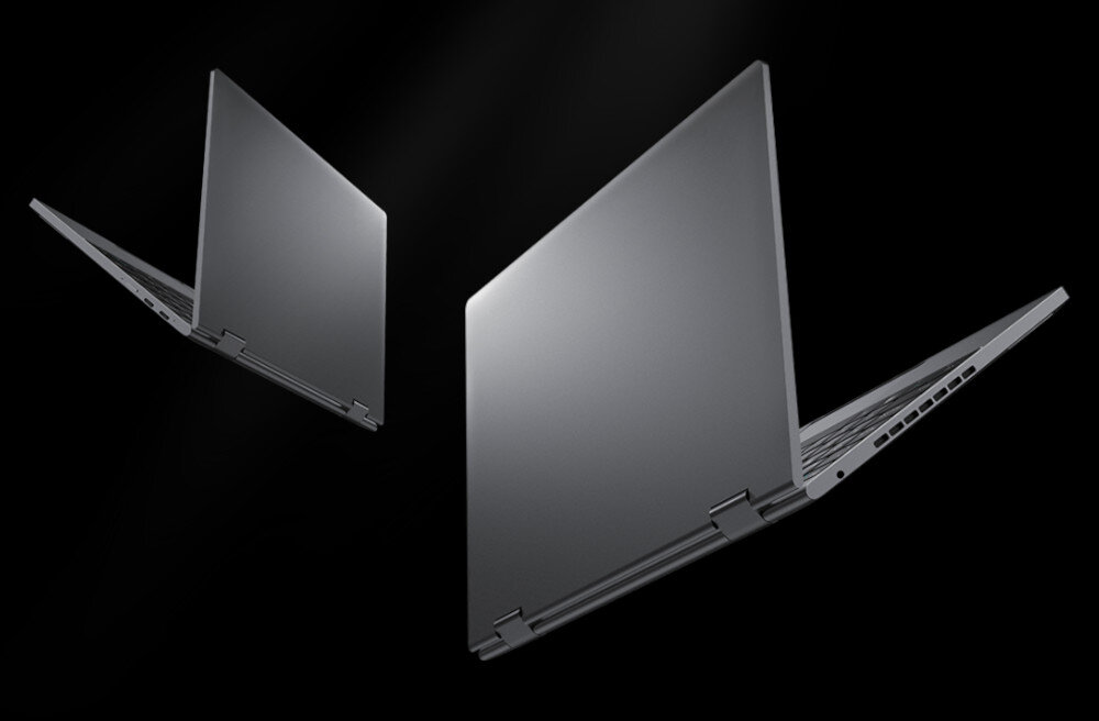 Dwa laptopy w kolorze srebrnym, otwarte pod kątem, widoczne na czarnym tle. Laptopy mają cienką konstrukcję i widoczne zawiasy.