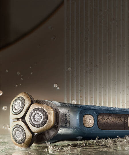 Srebnoniebieska golarka na półce. Na golarce krople wody.