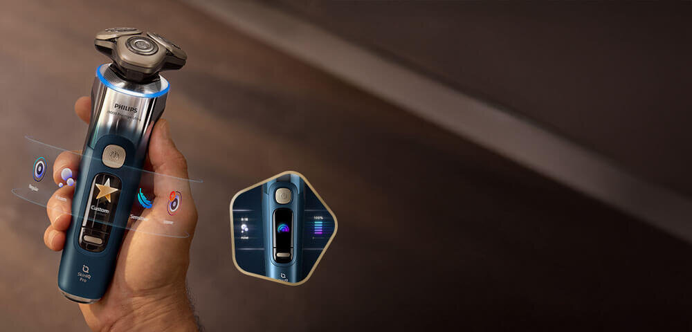 Głowice golarki z niebieskimi świetlnymi pięciokątami i strzałkami skierowanymi do wewnątrz. Obok małe zdjęcie golarki z głowicami przy twarzy i zielonym ringiem.