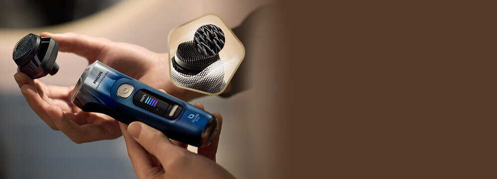 Mężczyzna z zarostem z golarką przy dolnej krawędzi twarzy. Obok małe zdjęcie głowicy, z 1 głowicą w szczegółowym przekroju.