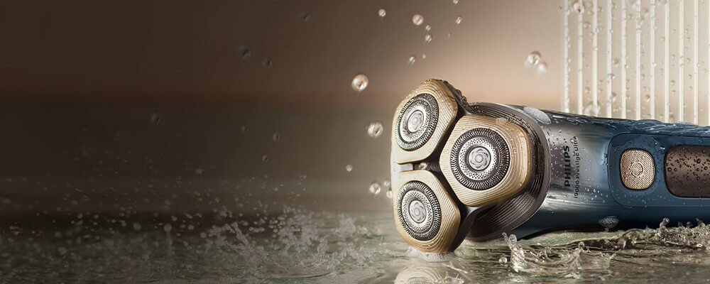 Srebnoniebieska golarka na półce. Na golarce krople wody.