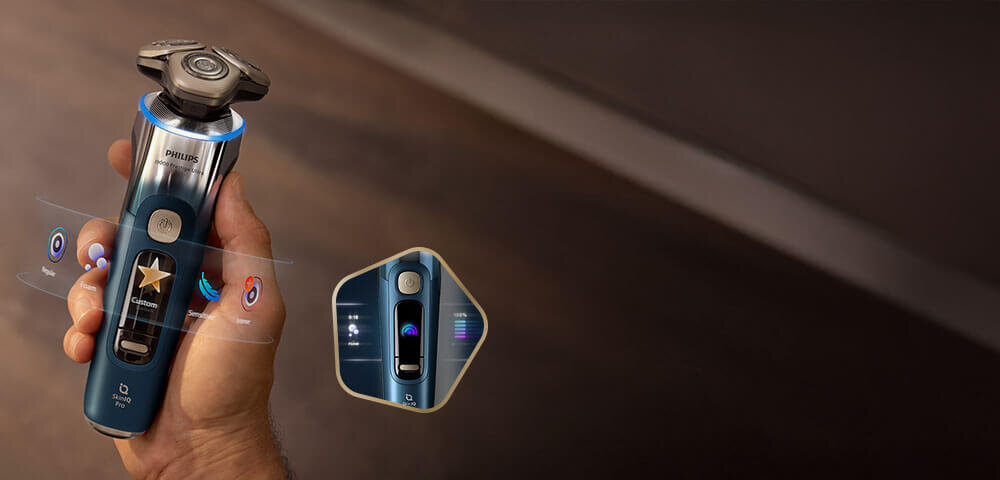 Głowice golarki z niebieskimi świetlnymi pięciokątami i strzałkami skierowanymi do wewnątrz. Obok małe zdjęcie golarki z głowicami przy twarzy i zielonym ringiem.