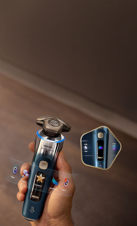 Głowice golarki z niebieskimi świetlnymi pięciokątami i strzałkami skierowanymi do wewnątrz. Obok małe zdjęcie golarki z głowicami przy twarzy i zielonym ringiem.