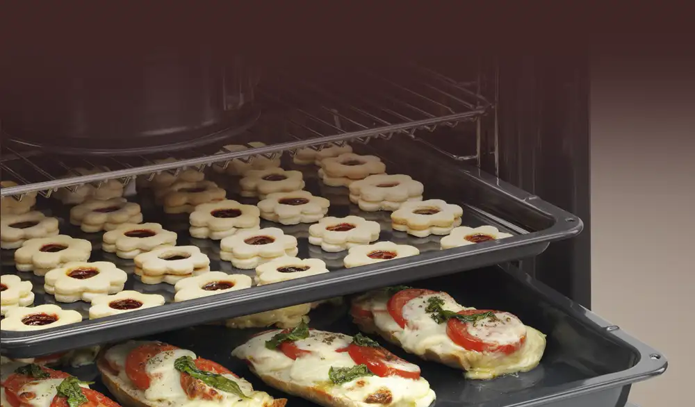 2 blachy z grzankami i ciastami oraz ruszt z ciastem