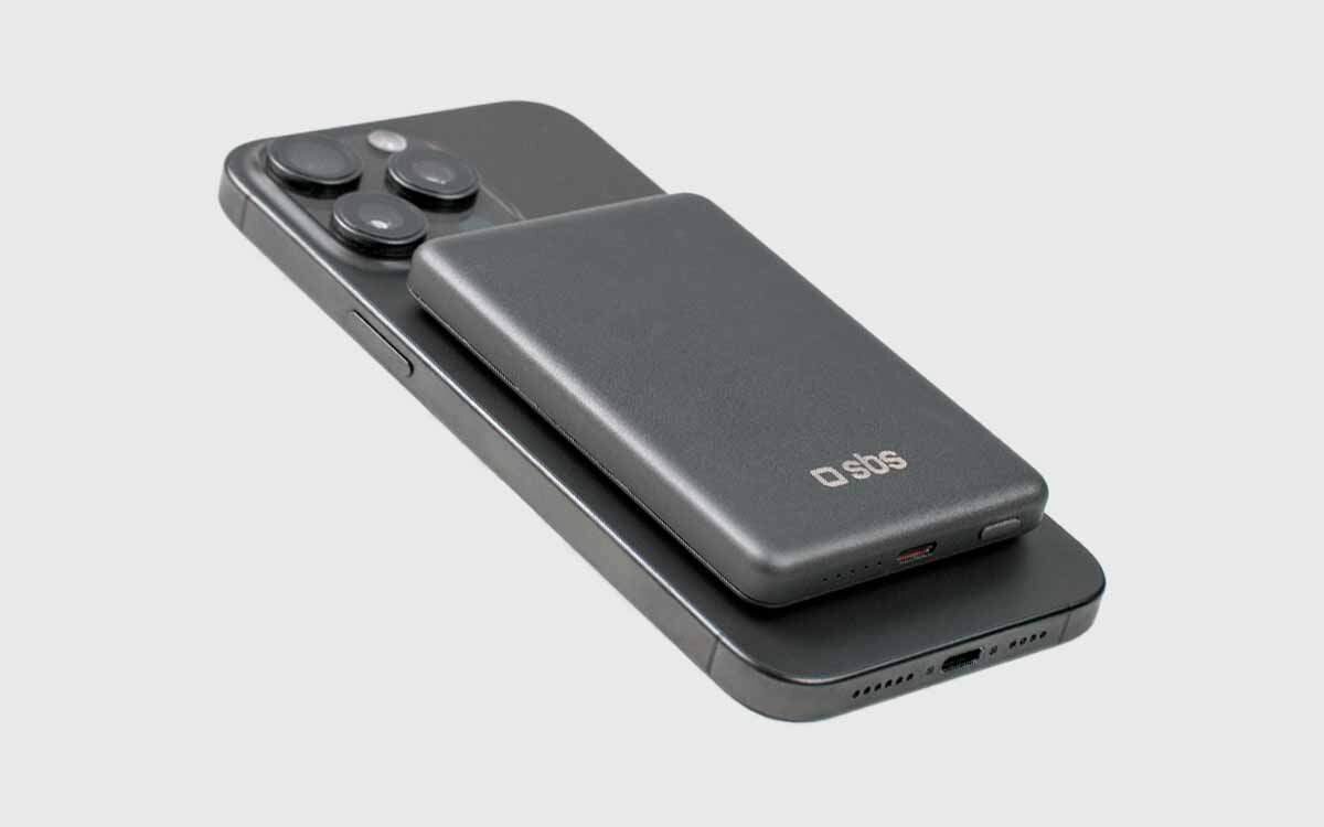 Powerbank SBS MagSafe Automatic Detection System (ADS) SBS MagSafe ładowanie bezprzewodowe chroni urządzenia przed przegrzaniem, przepięciem i zwarciami - powerbank z telefonem na jasnym tle