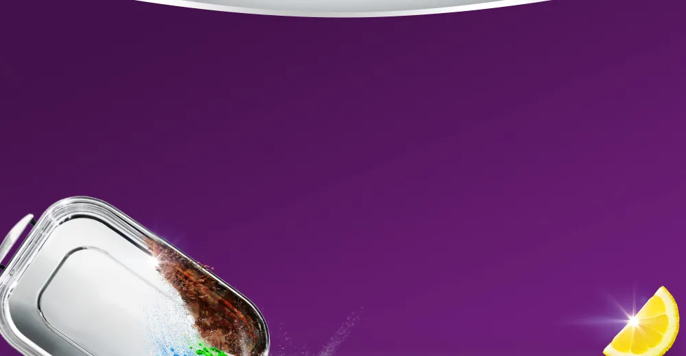 Blacha do pieczenia częściowo zabrudzona i częściowo czysta obok kawałka cytryny na fioletowym tle.
