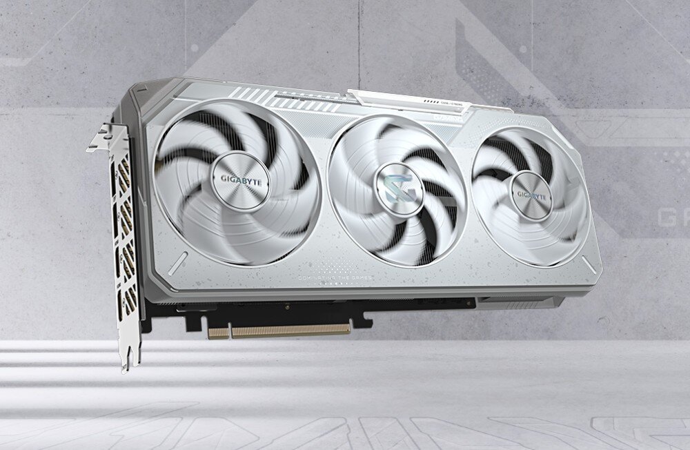 Komputer MAD DOG Powered By Gigabyte C500-ICE-A06DR32 Karta graficzna z trzema wentylatorami, umieszczona na futurystycznym, ciemnym tle z niebieskimi akcentami. Na obudowie karty widoczne są logotypy producenta oraz subtelne podświetlenie RGB, karta graficzna, architektura, technologie