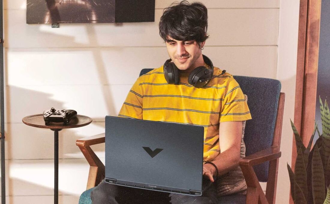 Laptop HP Victus 15 - Mężczyzna w słuchawkach siedzi na krześle, używając laptopa do pracy. Pamięć DDR5, Dysk SSD PCIe NVMe 