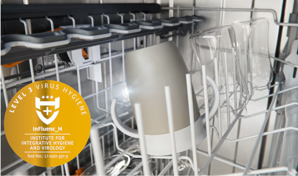 ZMYWARKA MIELE G 5662 SCVi Active S Zdjęcie przedstawia wnętrze zmywarki z umieszczonymi w koszu kubkami i szklankami, oświetlonymi delikatnym światłem podczas cyklu mycia. W lewym dolnym rogu widoczna jest grafika informująca o poziomie higieny Level 3 Virus Hygiene, potwierdzona certyfikatem Instytutu Higieny i Wirusologii, co podkreśla skuteczność urządzenia w usuwaniu drobnoustrojów 99,9% wirusów higieniczna czystość skuteczna dezynfekcja