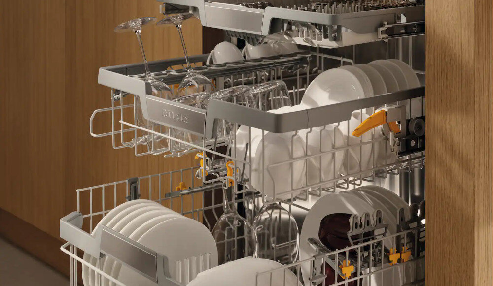 ZMYWARKA MIELE G 5662 SCVi Active S Zdjęcie przedstawia otwartą zmywarkę z trzema poziomami koszy, w których starannie ułożono talerze, szklanki oraz kieliszki. Ujęcie podkreśla dużą pojemność urządzenia oraz przemyślany układ elementów ułatwiający bezpieczne mycie delikatnego szkła i codziennej zastawy trwałość 5600 cykli niezawodność test jakości
