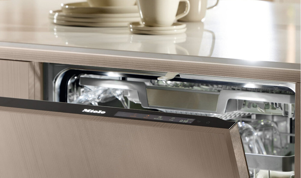 ZMYWARKA MIELE G 5811 SCi Active Plus CS Zdjęcie przedstawia częściowo otwartą zmywarkę z eleganckim panelem sterowania, na którym widoczne są podświetlone ikony i czas pracy programu. Górna część kadru ukazuje czyste naczynia ustawione na blacie, podkreślając skuteczność urządzenia i estetykę kuchni QuickPowerWash 58 minut UltraTabs szybkie suszenie wysoka skuteczność