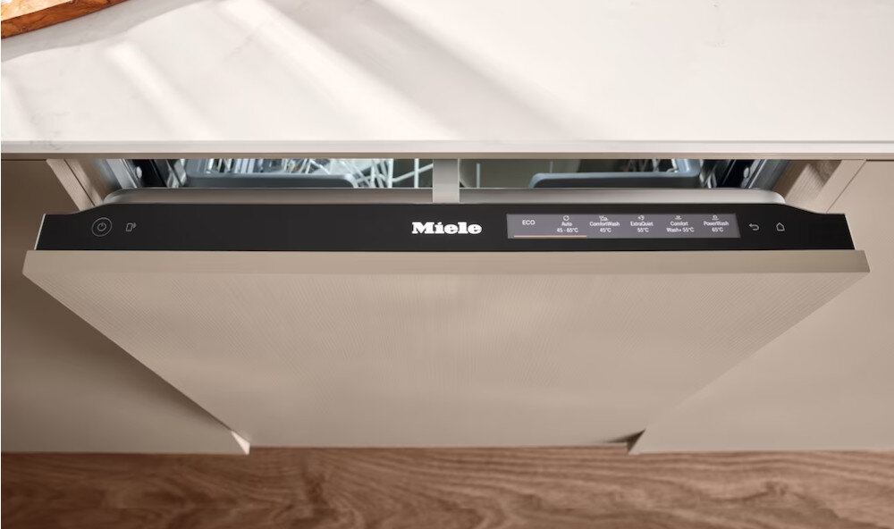 ZMYWARKA MIELE G 5811 SCi Active Plus CS Zdjęcie przedstawia panel sterowania zmywarki Miele umieszczony na górnej krawędzi frontu, z wyświetlonymi programami takimi jak ECO, QuickPowerWash i Intensive. Ujęcie podkreśla elegancki, zintegrowany design urządzenia oraz łatwy dostęp do funkcji podczas otwierania drzwi AutoOpen automatyczne otwieranie suche naczynia ochrona blatu