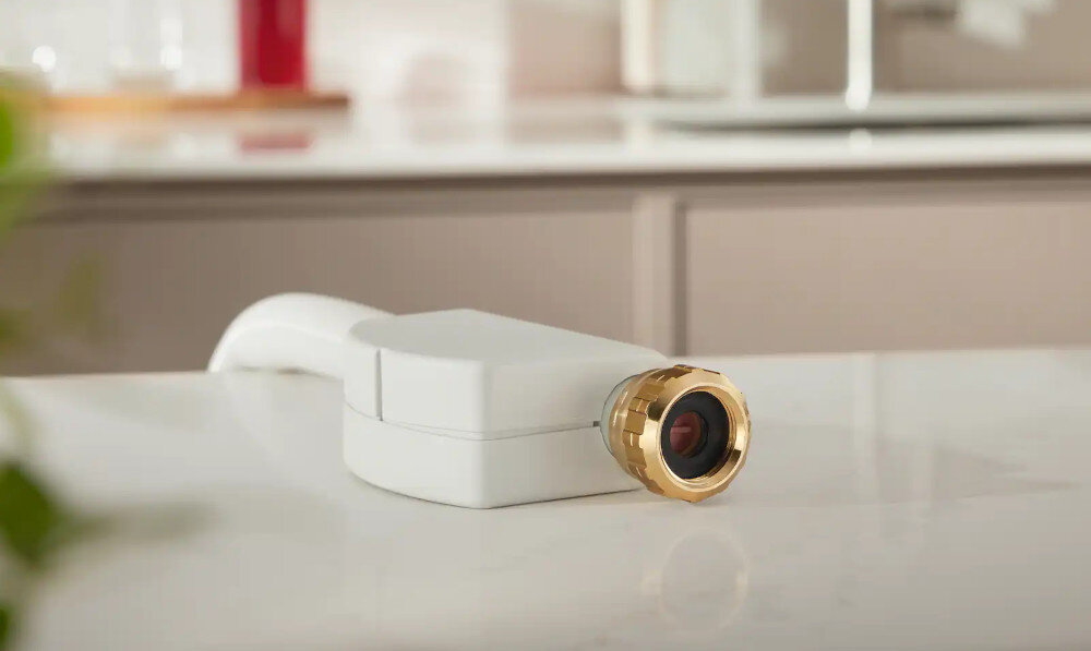 ZMYWARKA MIELE G5651 ACTIVE Zdjęcie przedstawia urządzenie z białą obudową i złotym, metalicznym zakończeniem, leżące na gładkim kuchennym blacie. Detal wykonania oraz miękkie oświetlenie podkreślają jego elegancki charakter przyłącze ciepłej wody 60°C 0,29 kWh krótszy czas energooszczędność