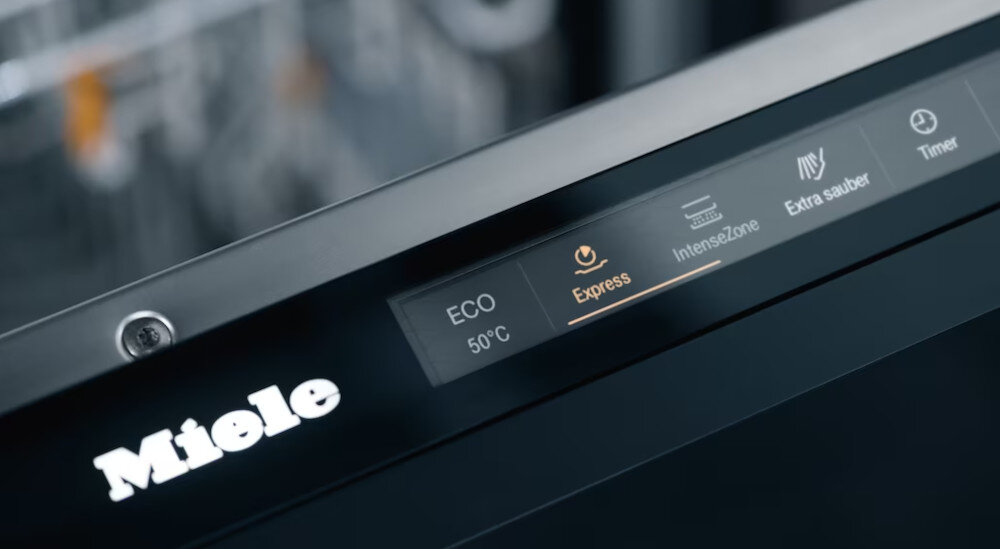 ZMYWARKA MIELE G 5862 SCVi Active Plus S Zdjęcie przedstawia panel sterowania zmywarki Miele z podświetlonym programem Express, który wyróżniony jest jasnym akcentem. Obok widoczne są także opcje ECO 50°C, IntenseZone, Extra sauber oraz Timer, podkreślające różnorodne funkcje urządzenia program Expres skrócenie czasu 50% szybkie zmywanie