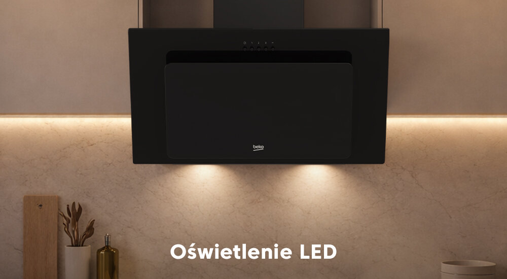 OKAP BEKO BHCA62332BH Przedstawiono czarny okap kuchenny Beko zamontowany nad płytą grzewczą, z włączonym oświetleniem LED. Światło równomiernie oświetla blat roboczy i ścianę pod okapem energooszczędne oświetlenie LED równomierne oświetlenie ułatwione gotowanie komfortowa atmosfera przyjemna kuchnia
