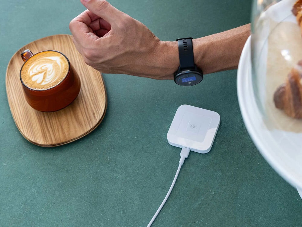 Zegarek sportowy GARMIN Vivoactive 6 osoba z zegarkiem na ręku w tle terminal do płatności powiadomienia ze smartfona płatności garmin pay pamięć na muzykę śledzenie aktywności sklep connext iq