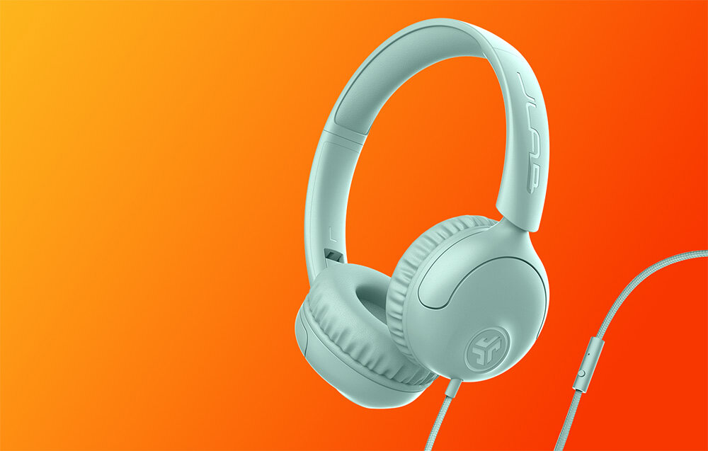 Słuchawki nauszne JLAB Studio 2 wygodne brzmienie przewodowe komfort codzienne użytkowanie, Błękitne słuchawki nauszne z kablem i pilotem, ustawione pod kątem na pomarańczowo-żółtym tle