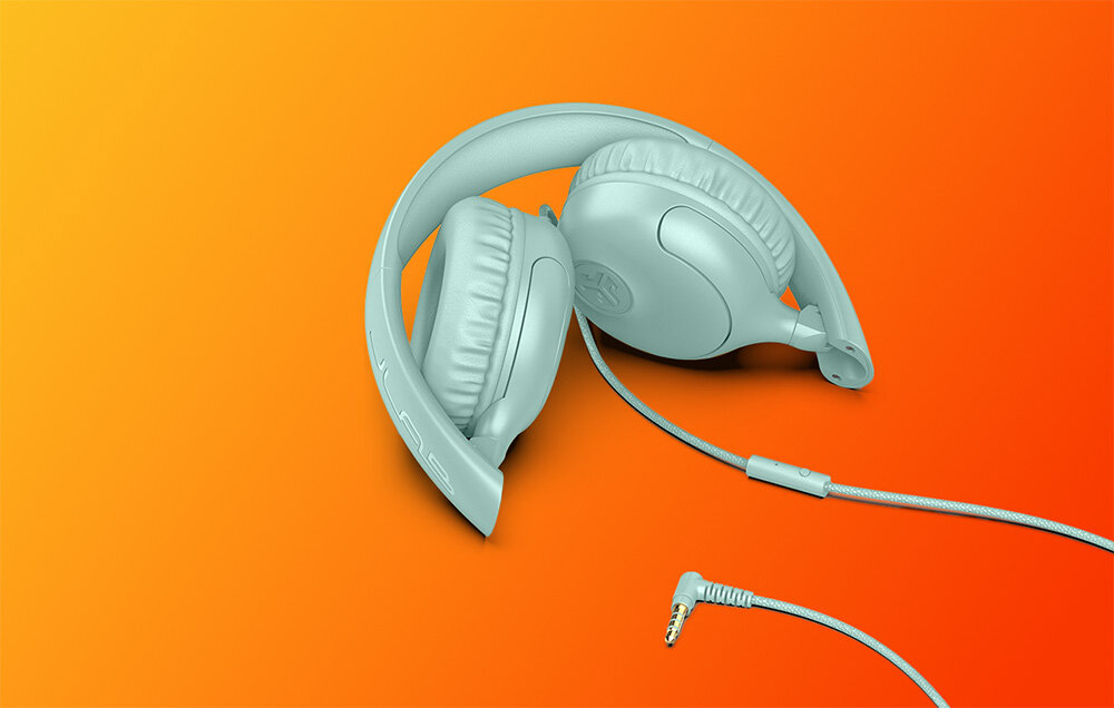 Słuchawki nauszne JLAB Studio 2 pleciony kabel 3,5 mm mini jack kompatybilność urządzenia audio, Złożone błękitne słuchawki przewodowe z widocznym wtykiem jack na pomarańczowej powierzchni