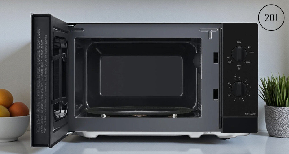 KUCHNIA MIKROFALOWA PANASONIC NN-GM22QBEPG Otwarta mikrofalówka wolnostojąca o pojemności 20 l, z widocznym szklanym talerzem w komorze, prostym pokrętłowym panelem sterowania oraz dekoracyjnymi dodatkami na blacie po bokach urządzenia kompaktowe wymiary 440x333x258 mm mała kuchnia pojemność 20 litrów szklany talerz 255 mm większe talerze standardowe naczynia oszczędność miejsca funkcjonalny design praktyczne rozwiązanie