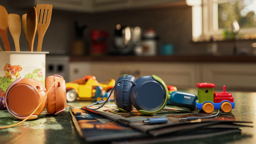 Słuchawki nauszne PHILIPS TAK2000CT wytrzymałe i składane dla dzieci, dwie pary słuchawek leżące na stole