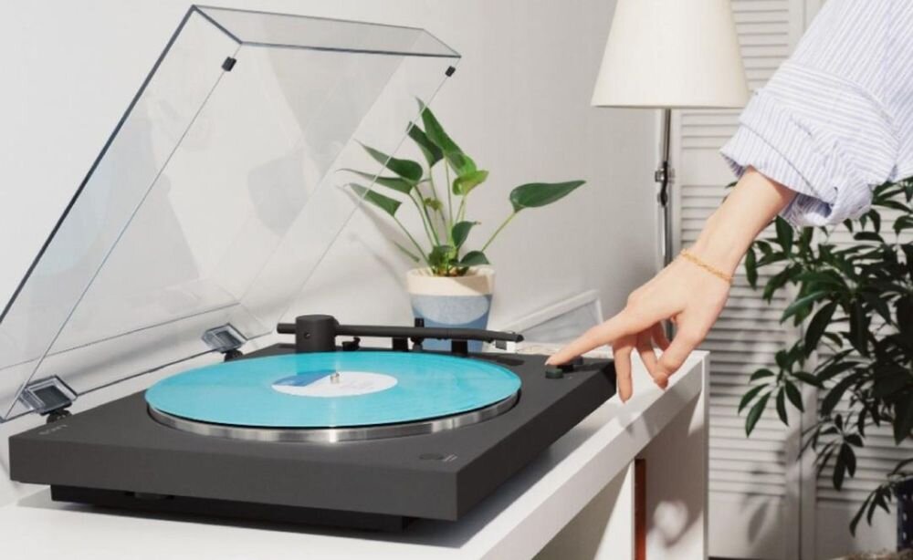 Gramofon SONY PS-LX3BT w pełni automatyczne odtwarzanie jeden przycisk, gramofon stojący na szafce , osoba dotykająca gramofonu