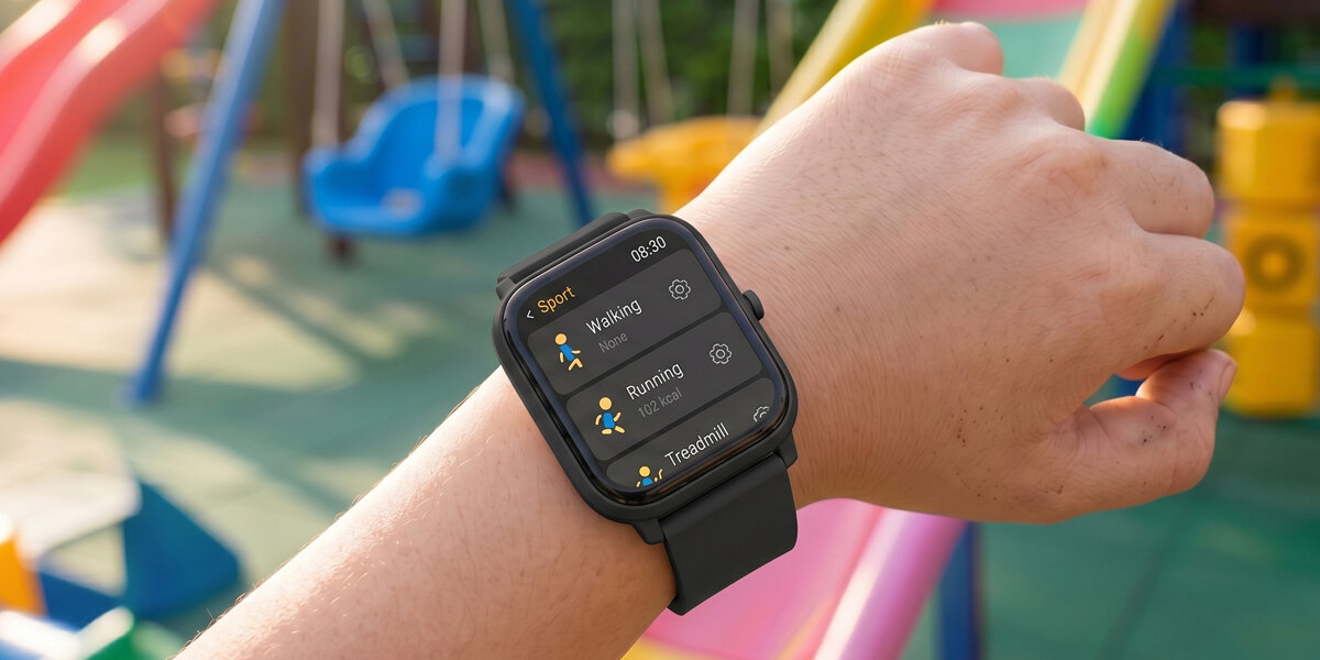 Ręka dziecka prezentuje czarny smartwatch Denver na kolorowym placu zabaw. Zegarek wyświetla menu sportowe.