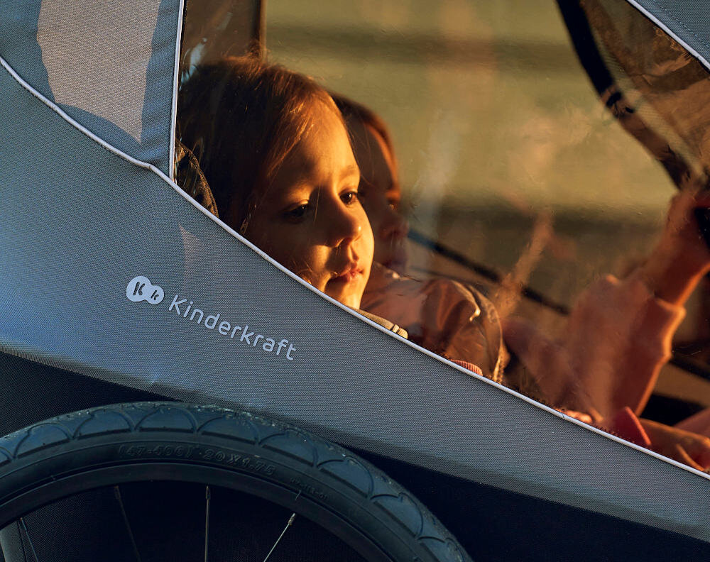 Przyczepka rowerowa KINDERKRAFT Nava Walk 2w1 60kg Pasy Czarno-szary przyczepka na białym tle widoczna pod skosem od przodu zintegrowany system wentylacji możliwość regulowania osłon podwinąć i przypiąć dostosowanie wnętrza do panujących warunków