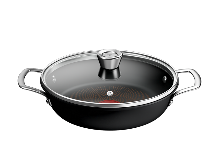 Czarna patelnia z pokrywką, posiada dwa uchwyty i szklane wieko z metalowym uchwytem. Na dnie patelni widoczny jest czerwony okrąg z promieniami.