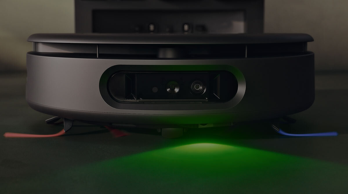 Robot Dyson Spot+Scrub AI ustawiony jest frontem i oświetla zielonym światłem podłogę przed sobą