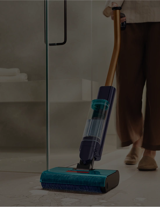 Osoba trzyma mop elektryczny Dyson Clean+Wash Hygiene i zmywa nim brudną podłogę