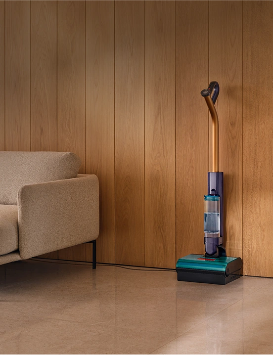 Mop po zakończonej pracy stoi w stacji dokującej umieszczonej pod ścianą. Przed nią jest czysta i lśniąca podłoga