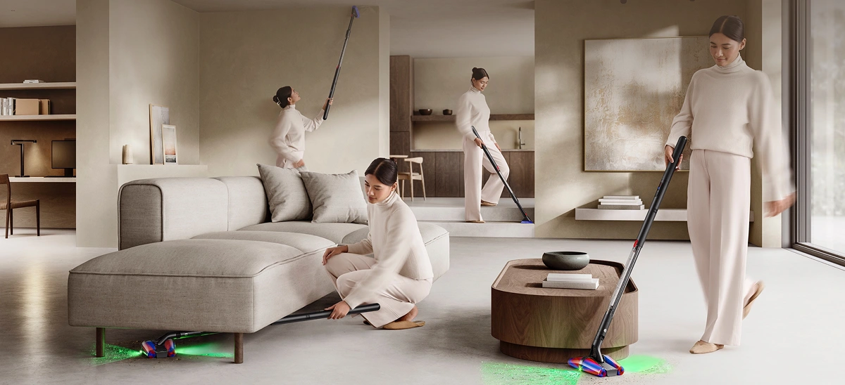 Sprzątanie odkurzaczem Dyson Pencilvac różnych części pokoju: pod sofą, wokół stolika, przy krawędzi sufitu i na schodach