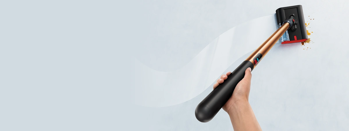 W ujęciu od góry widać mop w kobiecej dłoni. Za mopem jest nieregularny lśniący ślad świeżo umytej podłogi