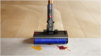 Zbliżenie na elektroszczotkę stojącą na krawędzi dwóch rodzajów podłóg twardych
