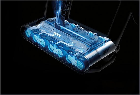 Obraz przedstawia przezroczystą głowicę odkurzacza z widocznymi wewnętrznymi elementami w kolorze niebieskim. Tło jest ciemne, co podkreśla szczegóły konstrukcji urządzenia.