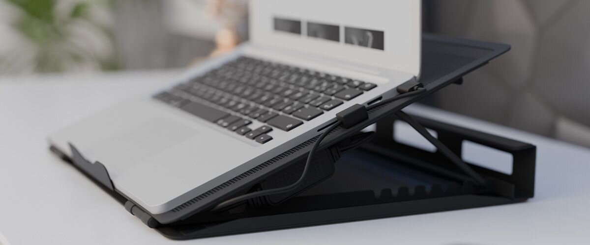 Natec Tern 2 Plus akcesoriów przewodowych Dedykowane przepusty kablowe estetyczne prowadzenie kabli specjalne otwory - Laptop umieszczony na regulowanym stojaku o eleganckim wyglądzie, widoczny kabel połączeniowy.