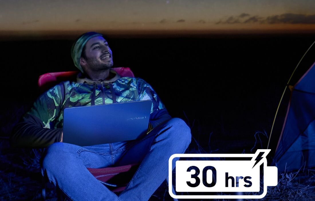 Mężczyzna używa laptopa MSI Prestige z baterią 30 hrs podczas pracy zdalnej przy namiocie o zmierzchu - Bateria do 30 godzin pracy na jednym ładowaniu  
