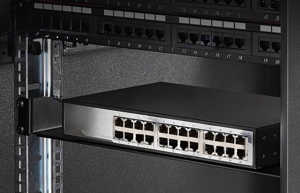 Półka EXTRALINK EX.28846 Czarna szafa rackowa z zamontowaną wewnątrz metalową półką, na której stoi switch sieciowy, a powyżej widoczne są panele krosownicze