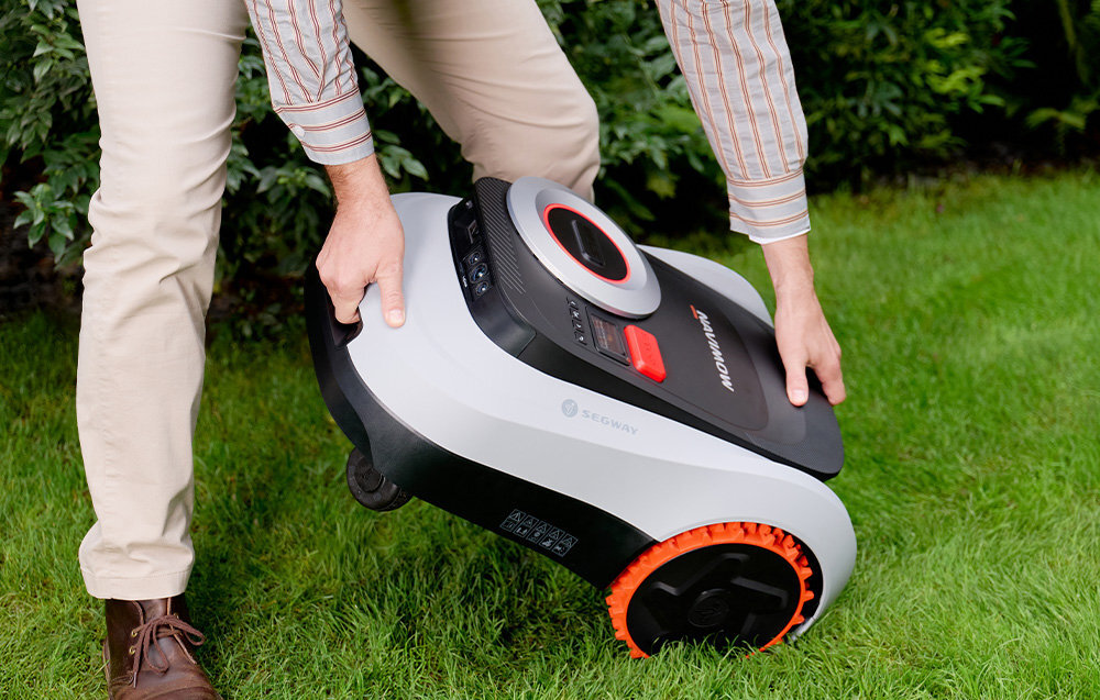 Robot koszący SEGWAY NAVIMOW i210E ogród trawnik osoba podnosi robota z trawnika system GPS wykrywanie podniesienia alarm graniczny obsługa Apple Find My wbudowany wyświetlacz LCD łączność Bluetooth, Wi-Fi i komórkowa aktualizacje OTA